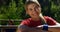 Portrait of female trainer leaning on wooden frame during obstacle course