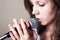 Portrait of female vocalist on gray background closeup