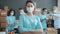 Portrait of female volunteer wearing medical mask and gloves standing in charity company