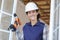 Portrait female window fitter holding cordless drill