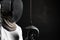 Portrait of fencer woman wearing white fencing costume practicing with the sword. Isolated on black background.