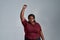 Portrait of fierce plus size young african american woman in casual clothes looking at camera, standing with fist raised