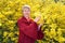 Portrait of the fifty-year-old woman against the background of the blossoming forsythia