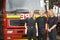 Portrait of firefighters standing by a fire engine