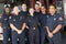 Portrait of firefighters standing by a fire engine