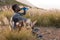 Portrait of fit african american man in sportswear resting drinking water in tall grass