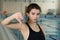 Portrait of a fit female swimmer gesturing thumbs down by the pool at leisure center