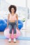 Portrait of a fit woman sitting on fitness ball at gym