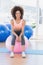 Portrait of a fit woman sitting on fitness ball at gym