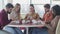 Portrait of five bored caucasian people sitting in cafe and using smartphones. Young indifferent men and women chatting