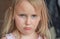 Portrait of a five-year-old girl, blonde, sweet, pretty, offended, upset,