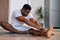 Portrait of flexible African-American man practicing yoga sitting in Janu Sirsasana exercise