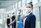 Portrait of flight attendant standing on airport, wearing face masks.