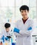 Portrait focus to young scientist asian man wearing uniform standing put hands in pocket and smiling feel happy and comfortable