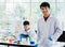 Portrait focus to young scientist asian man wearing uniform standing put hands in pocket and smiling feel happy and comfortable