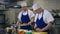 Portrait of focused Caucasian cook in uniform cutting vegetables with knife in restaurant kitchen in slow motion with