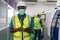 Portrait of foreman engineer worker labor ware face mask with machine in factory plant.