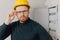 Portrait foreman man in yellow helmet inspecting electrical panel and work of electrician in apartment