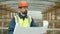 Portrait of foreman wearing uniform checking blueprint and looking at construction site outdoors