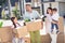 Portrait of four cheerful people dad mom small little kids brother sister holding in hands cardboard boxes things