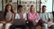 Portrait of four friendly university students sit in library