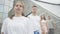 Portrait of four joyful Caucasian young dancers standing in a row on urban stairs and moving hands. Cheerful young men