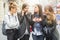 Portrait of four pretty girl friends, gossip on the street