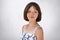 Portrait of freckled little girl with dark short hair, hazel eyes and thin lips wearing black and white dress, posing at camera ag