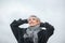 Portrait of a free, independent and happy mature woman in warm clothes against a gray autumn sky