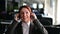 Portrait of friendly call center operator woman putting on headset in office. A smiling female hotline employee in