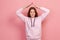 Portrait of friendly curly haired teenager girl in hoodie showing house roof symbol over head and smiling, feeling secured