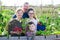 Portrait of friendly family with children at the fence of garden