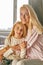 Portrait of friendly mother and child girl in bedroom