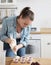 Portrait of friendly smiling female make a cupcake with cream. Indoors image.