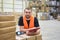 portrait of friendly warehouse worker in a forwarding agency - interior with forklift - transport and storage of goods