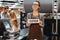 Portrait of friendly woman cashier holding open sign