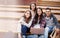 Portrait of friends with laptop on campus steps, happiness and online education in college with diversity. Learning