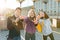 Portrait of friends teen boy and two girls smiling, making funny faces, showing victory sign in the street. City background,