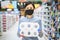 Portrait of a frightened young woman in a protective mask and gloves holding packaging with toilet paper in a supermarket