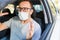 Portrait of frustrated man wearing surgical mask while driving a car