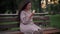 Portrait of frustrated senior Caucasian woman eating sandwich sitting on bench in park on windy overcast day. Medium