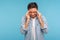 Portrait of frustrated unhealthy man in denim shirt pressing fingers to temples, feeling sick and suffering severe headache