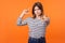 Portrait of frustrated young woman with brown hair in long sleeve shirt showing looser gesture. indoor studio shot isolated on