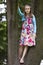 Portrait in full growth of girl stands on the branches of a tree.