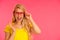 Portrait of a funky young woman in yellow t shirt over pink back