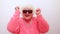 Portrait of funny amazed surprised senior blonde woman in sun glasses and pink sweater on white background having fun