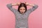 Portrait of funny angry woman in striped sweatshirt showing bull horn gesture and looking with hate rage