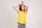Portrait of funny carefree attractive teenager girl in yellow T-shirt showing bunny ears gesture and