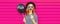 Portrait of funny cheerful young woman having fun holding black balloon, showing mustache on stick on pink background