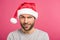 portrait of funny confused man in santa hat, isolated